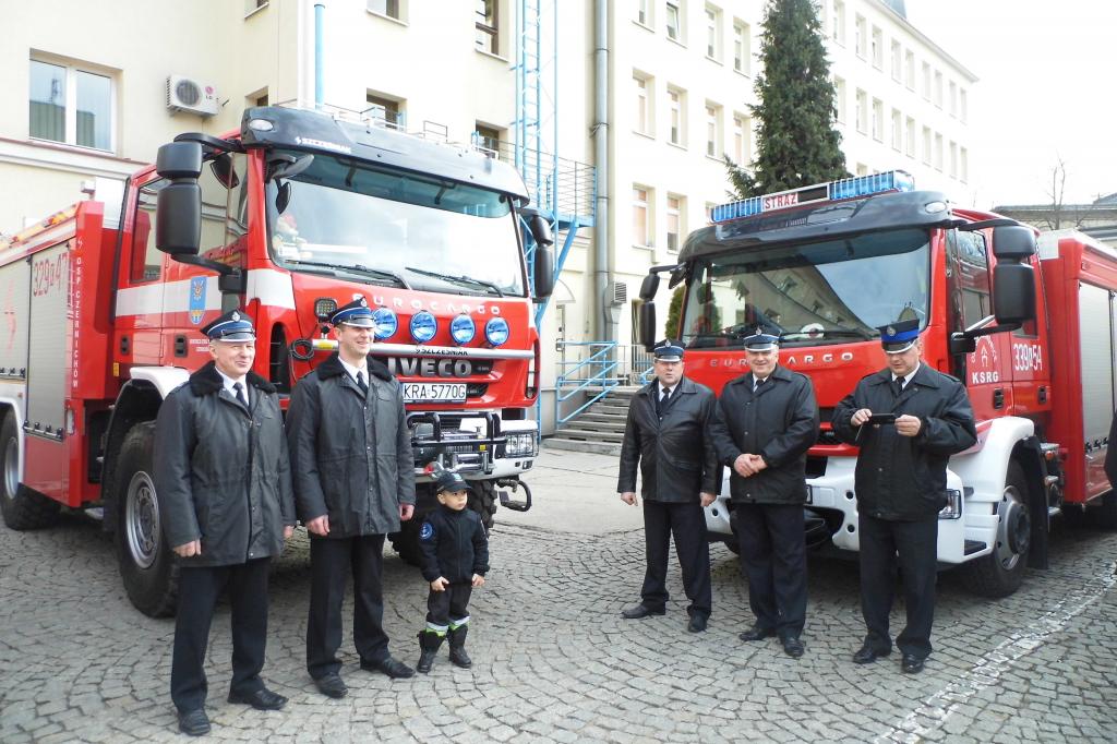 Druhowie z OSP Sieciechowice oraz z Czernichowa (wraz z najmłodszym druhem) przed samochodami strażackimi