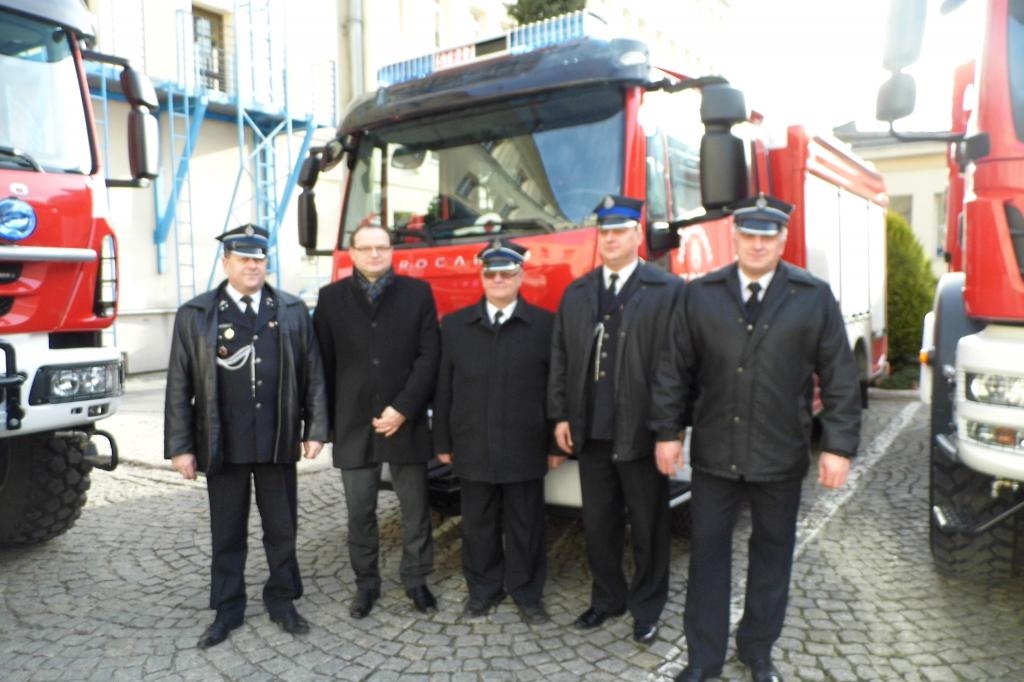 Druhowie z OSP Sieciechowice, prezes Zarządu Gminnego OSP oraz Wójt Gminy przed samochodem strażackim
