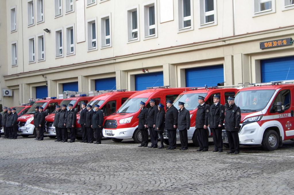 Samochody strażackie, a przed nimi Druhowie OSP